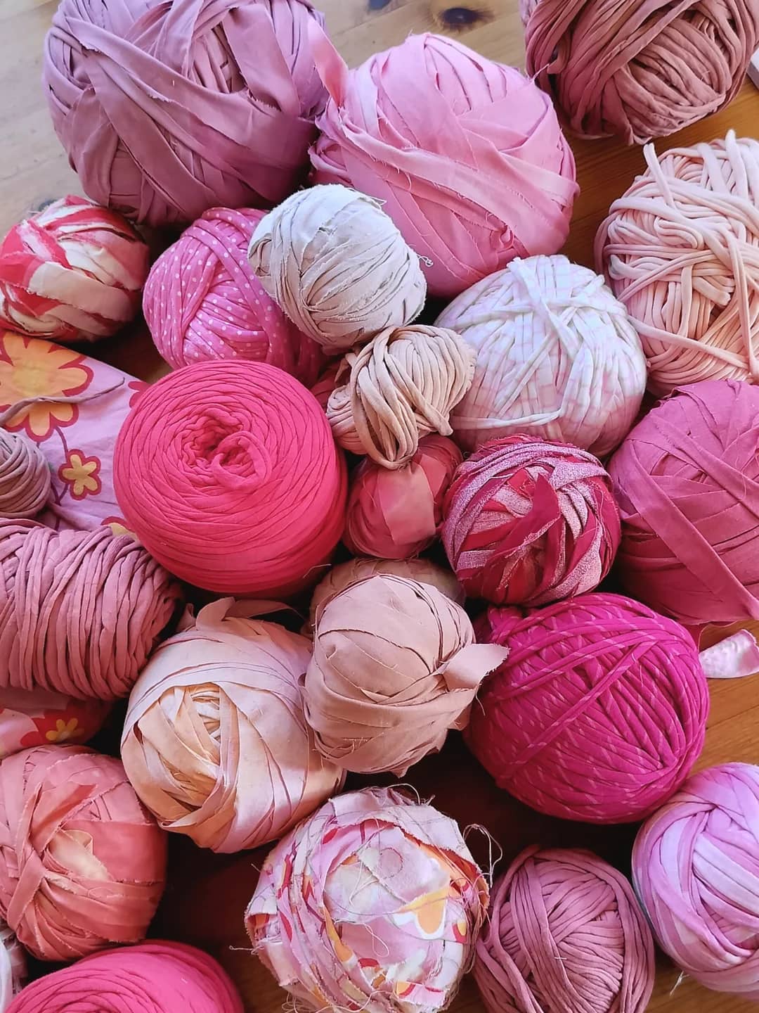 Organized piles of fabric strips sorted by colour on a studio table.